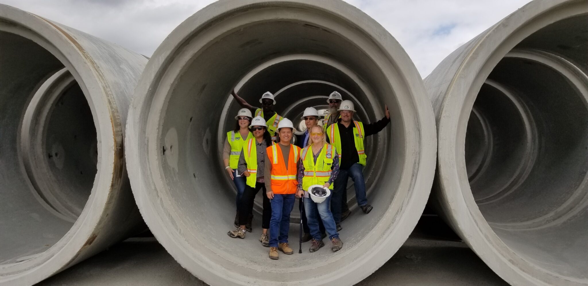 PWA Employees posing in a large drain pipe